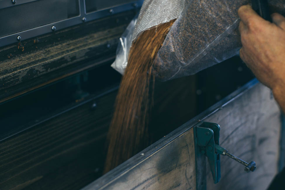 Holzspähne werden in eine Lucke geschüttet